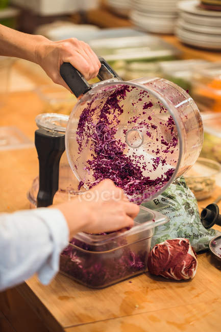 Hands putting cabbage to container — Stock Photo