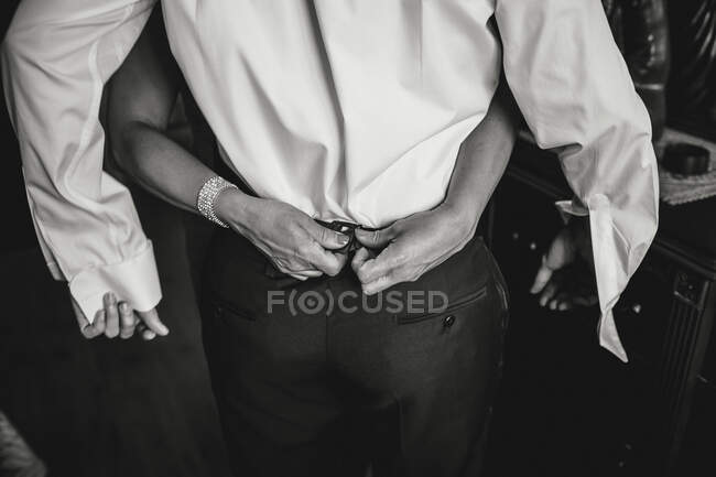 Schwarz-Weiß-Aufnahme von Händen, die Hosen für stilvollen Mann zuknöpfen. — Stockfoto