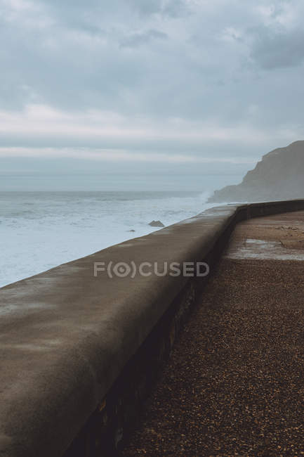 Pavimentado frente al mar vacío en tormenta - foto de stock