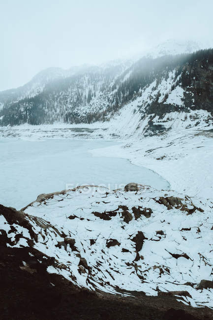 Замерзшее озеро в снежных горах — стоковое фото