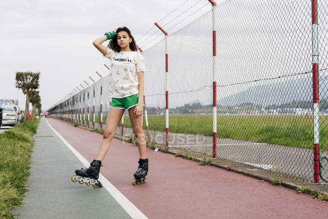 Chica en patines sobre terreno de deportes - foto de stock