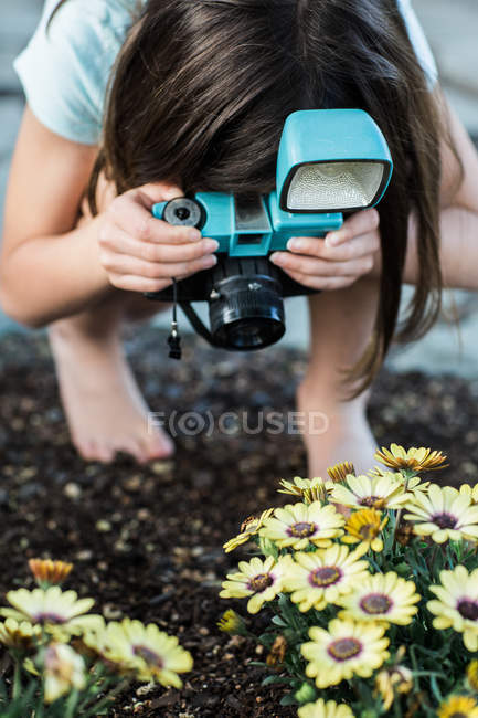 Fille prenant des photos de fleurs — Photo de stock
