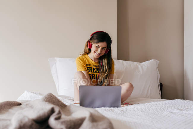 Жінка в навушниках використовує ноутбук — стокове фото