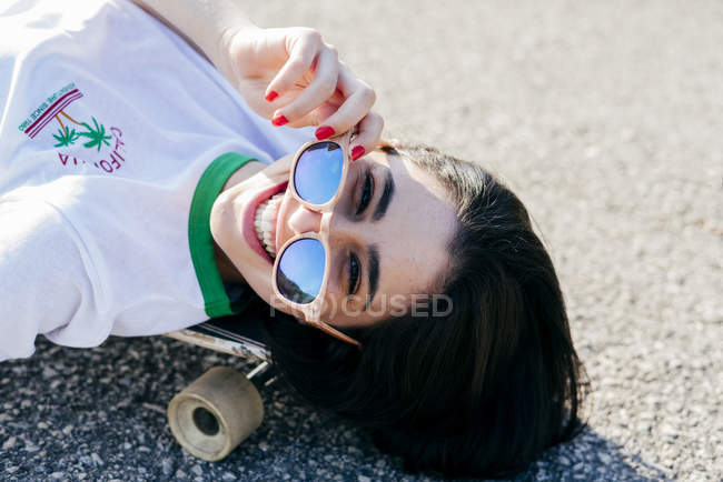 Teenage girl lying on longboard — Stock Photo