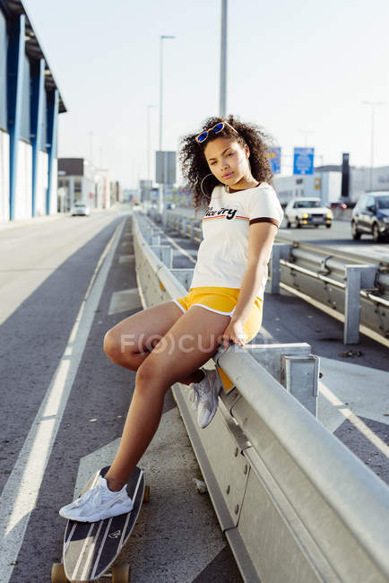 Teenage girl leaning on guard rail — Stock Photo
