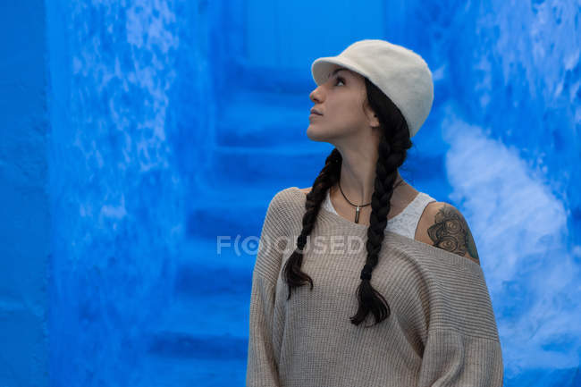 Femme regardant mur bleu sur le bâtiment — Photo de stock