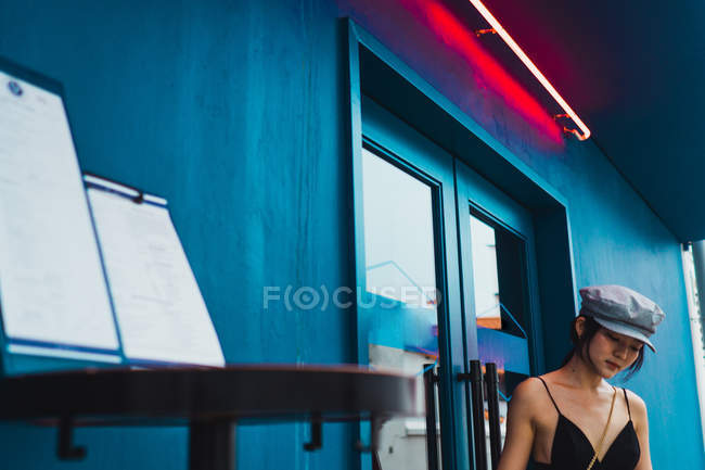 Elegante joven mujer asiática de pie en la puerta de la calle - foto de stock