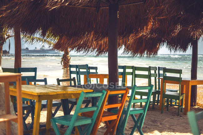 Leere bunte Stühle und Tische eines Cafés im Freien unter Schutz an der Küste der Karibik, Mexiko — Stockfoto