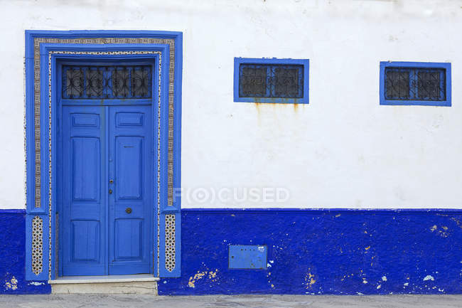 Típicas puertas de entrada árabe en edificio azul y blanco, Marruecos - foto de stock