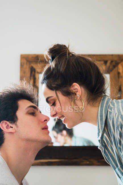 Jovem casal beijando com espelho no fundo — Fotografia de Stock