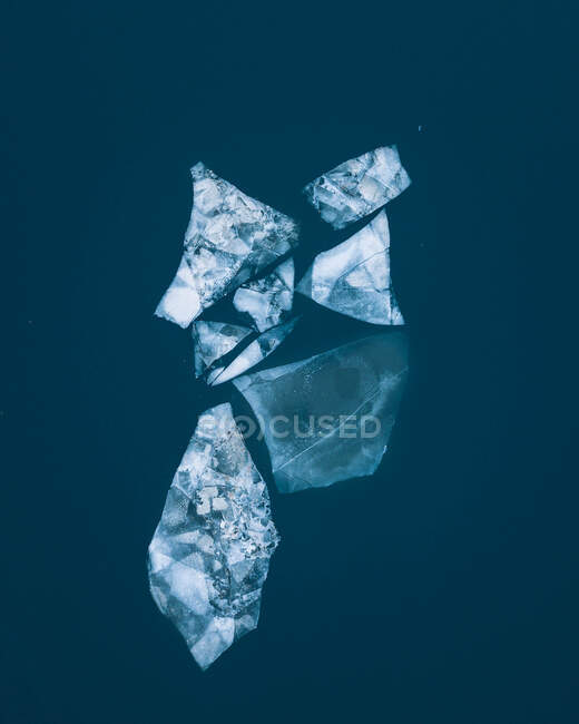 De cima pedaços de gelo derretendo flutuando em água azul. — Fotografia de Stock