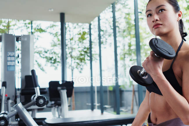 Woman working out with dumbbells in gym — Stock Photo