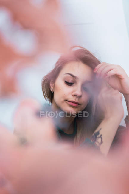 Primo piano di bella giovane donna con tatuaggio guardando giù — Foto stock