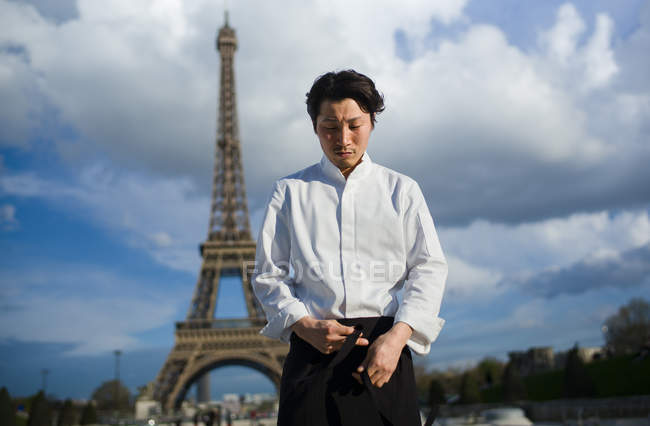Japanese chef wearing uniform standing in front of Eiffel Tower in Paris — Stock Photo