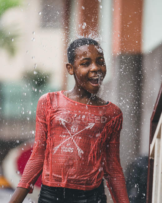 КАМЕРУН - Африка - 5 апреля 2018 года: Этническая девушка, стоящая под каплями воды — стоковое фото