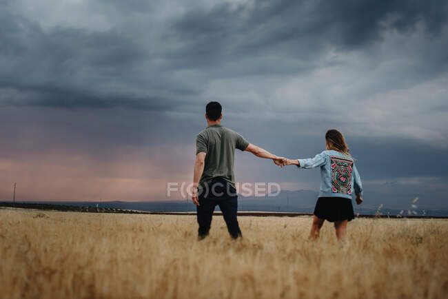 Pareja de pie en el campo seco - foto de stock