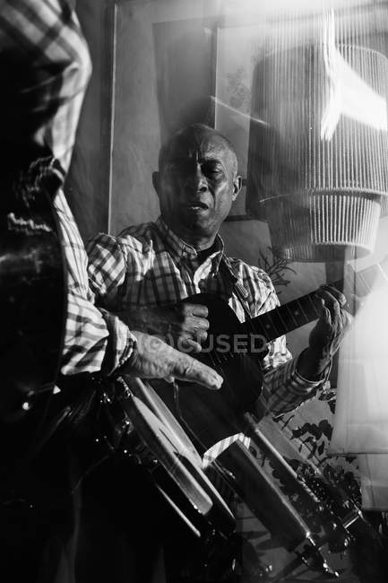 Кубинські музиканти грають на гітарі та барабанах у нічному клубі, чорно-білий постріл з довгим виступом. — стокове фото