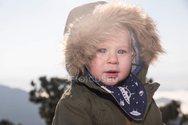 Portrait of Cute little boy in warm jacket standing in nature — Stock Photo