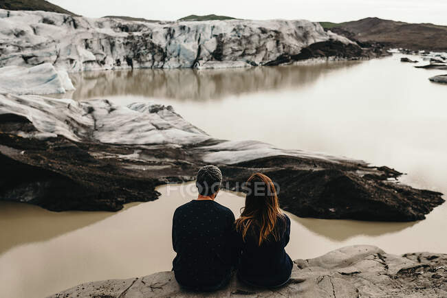 Couple sitting at dirty lakes — Stock Photo