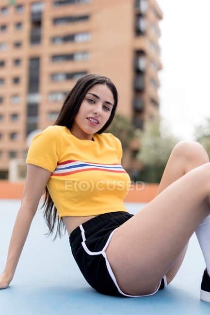 Young woman sitting on sports ground — Stock Photo