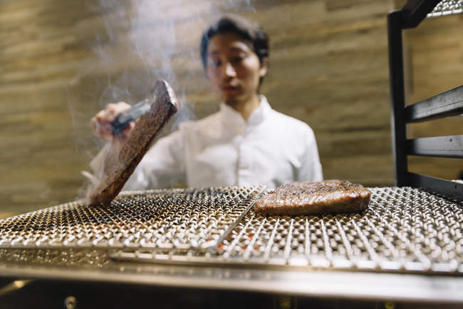 Chef preparando carne assada em restaurante — Fotografia de Stock
