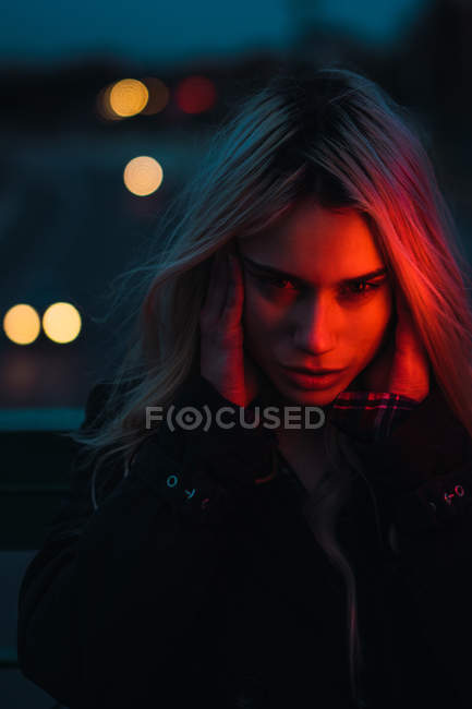 Portrait of thoughtful blonde woman holding head at dusk — Stock Photo