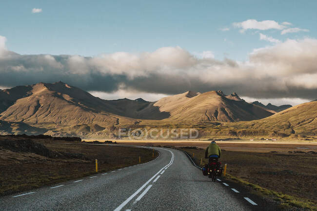 Вид на зворотній бік мандрівника на мотоциклі на дорозі в схилі пагорба . — стокове фото