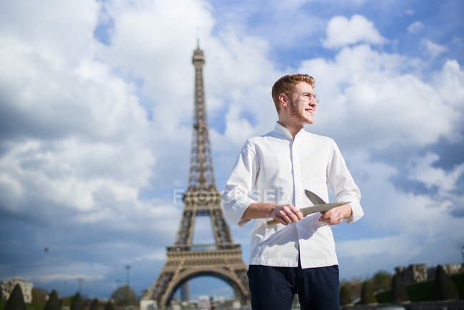 Smiling Red-Hair cook with knives in Paris standing in front of Eiffel Tower in Paris — Stock Photo