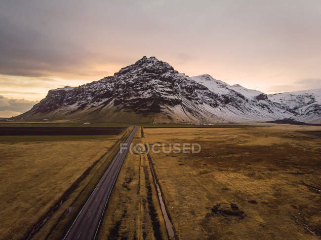 Camino de asfalto en la naturaleza con nubes y montañas, Islandia - foto de stock