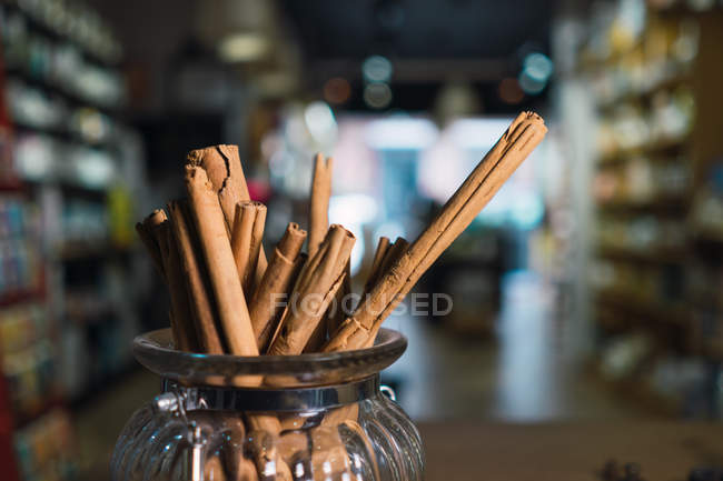 Cinnamon sticks in jar on table in shop — Stock Photo