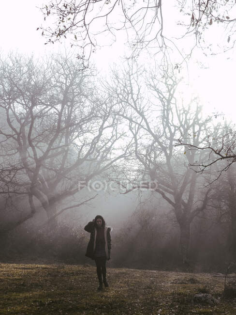 Femme dans un mystérieux parc froid seul — Photo de stock