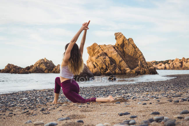 Apto jovem mulher exercitando na praia — Fotografia de Stock