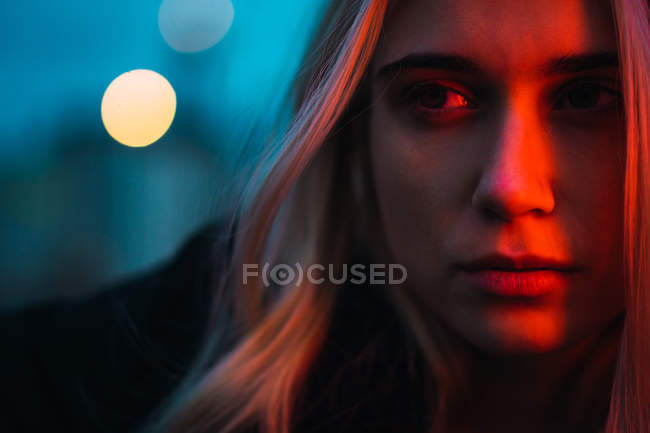 Femme blonde réfléchie regardant loin dans le crépuscule — Photo de stock