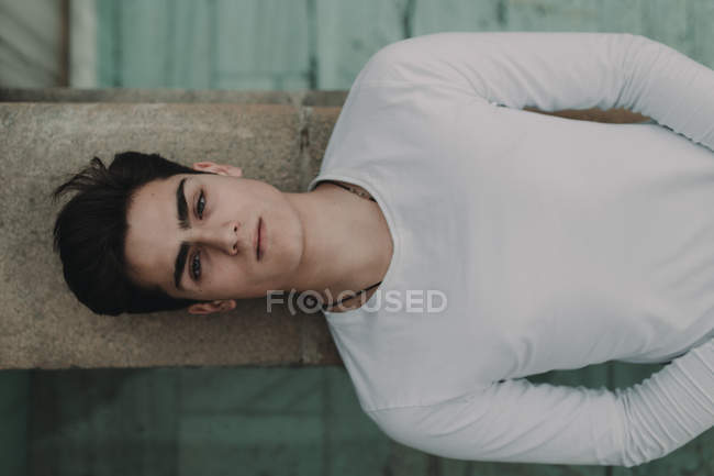 Молодий красивий чоловік лежить на бетонній стіні — стокове фото