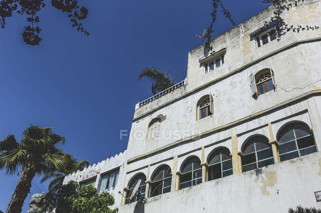 Viejo edificio de mala calidad frente al cielo azul, Tanger, Marruecos - foto de stock