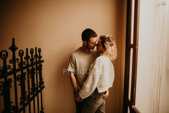 Romantisches junges Paar, das sich zu Hause umarmt — Stockfoto