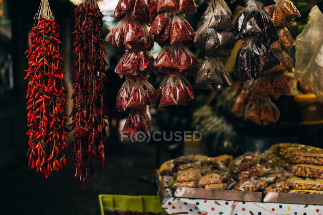 Différentes épices suspendues et posées sur le comptoir au marché fermier — Photo de stock