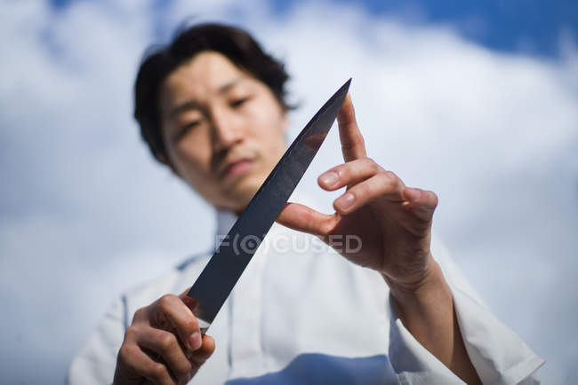 Chef japonais couteau de contrôle devant le ciel bleu — Photo de stock