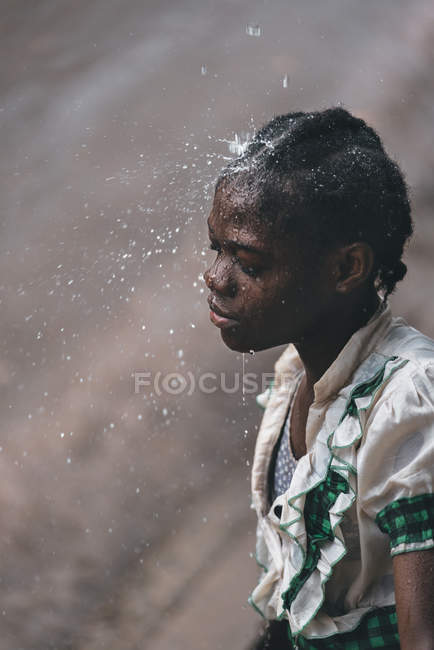 CAMARÕES - ÁFRICA - ABRIL 5, 2018: Menina étnica em pé debaixo de gotas d 'água — Fotografia de Stock