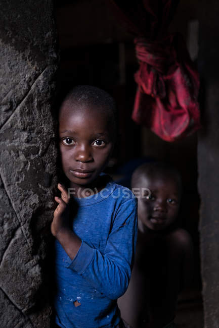 ANGOLA - AFRICA - APRIL 5, 2018 - Little black kids at grungy house looking at camera — Stock Photo