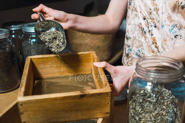 Human hands throwing spices in box in shop — Stock Photo