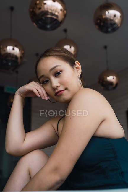 Ritratto di giovane donna asiatica seduta in appartamento moderno — Foto stock