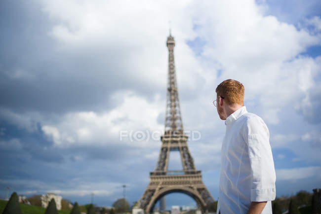 Cuisinière aux cheveux roux en chemise blanche devant la Tour Eiffel à Paris — Photo de stock