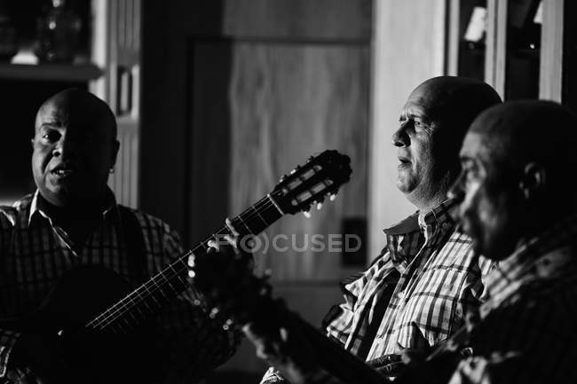 Trío musical cubano actuando en discoteca, plano blanco y negro con larga exposición - foto de stock