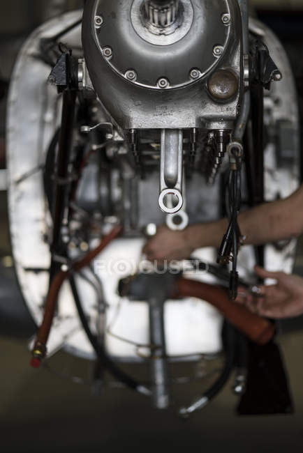 Las manos del motor de fijación mecánico de aeronaves de avión pequeño en hangar - foto de stock