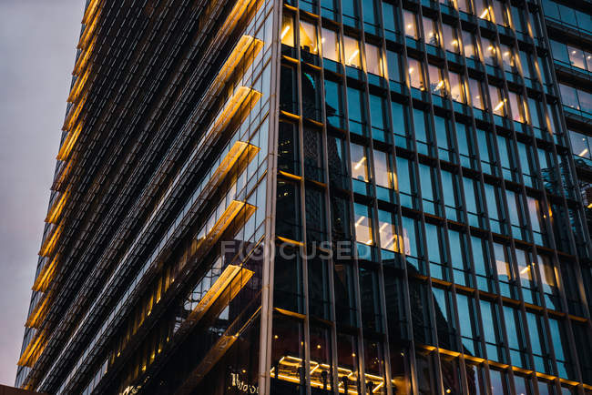 Primo piano di torre di ufficio alta illuminata in sera — Foto stock
