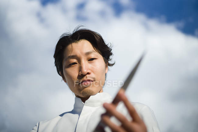 Японский шеф-повар проверяет нож перед голубым небом — стоковое фото