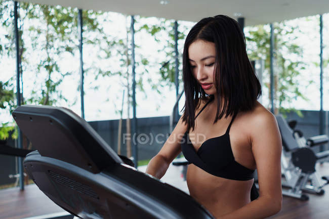 Asiatique femme réglage course piste dans gym — Photo de stock