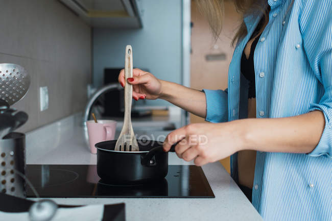 Donna in reggiseno e camicia cucina la prima colazione in cucina — Foto stock