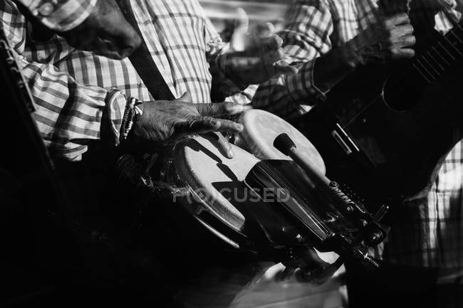 Recadré de musiciens jouant de la batterie et de la guitare en boîte de nuit, plan noir et blanc avec une longue exposition — Photo de stock